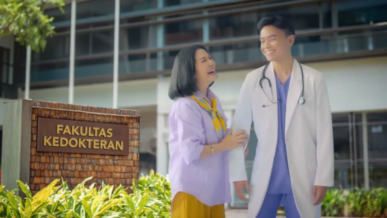 A mother celebrates with her son outside a medical faculty building