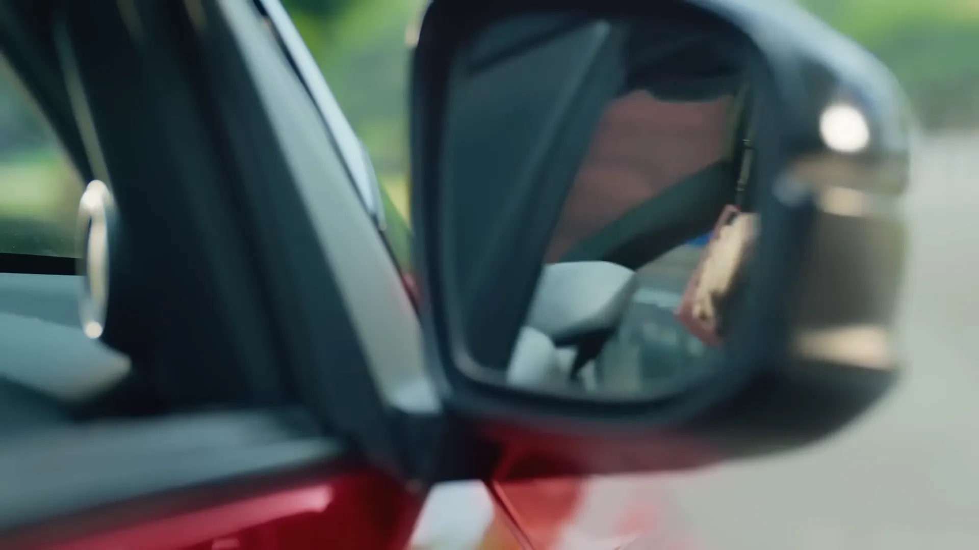 A close-up of the wing mirror of a red Honda, from the Start with Trust series